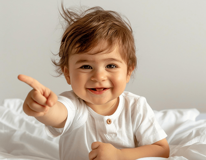Bebé sonriente señalando con el dedo